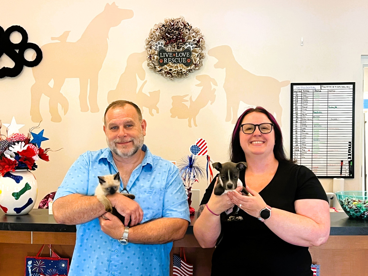 Picture of Executive Director Charles Brown holds Kitten, Bubbles, and Communications and Development Coordinator Caitlin Donnelly holds Puppy, Knox. Both animals are available for adoption.